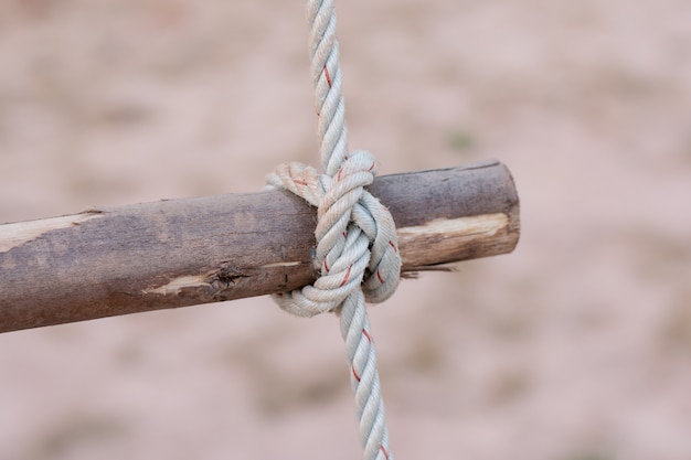 Una corda è legata in un nodo attorno a una staccionata, corda legata nodo palo di legno