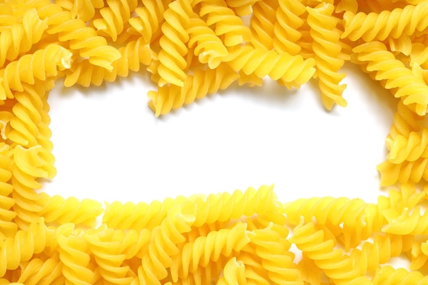 Una cornice fatta da fusilli crudi sparsi su tavola bianca Mock Up maccheroni crudi e secchi