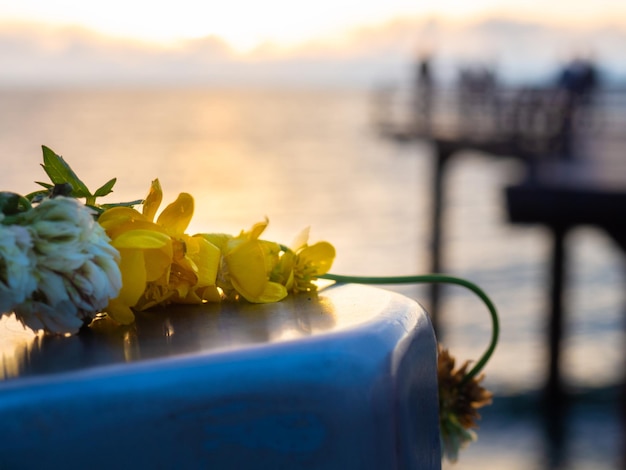 Una corona di fiori alzato sullo sfondo del sole al tramonto Bella vista sul mare Fiori abbandonati
