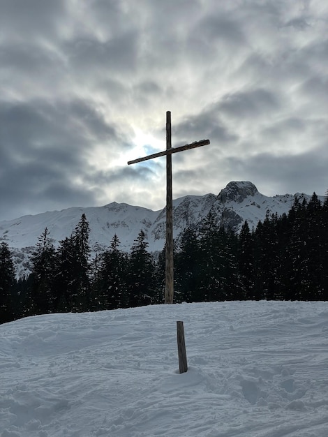 una croce in cima a una collina belle nuvole e vista del sole in montagna