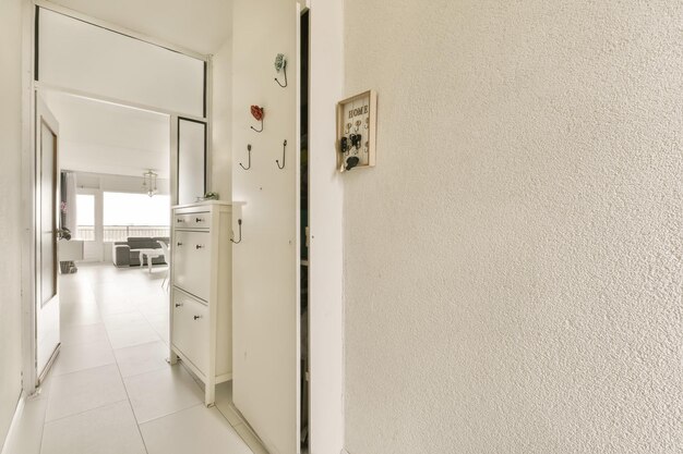 Una cucina bianca con una porta sul soggiorno