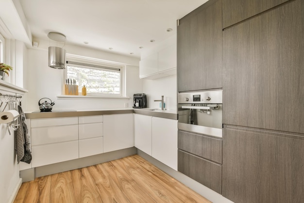una cucina con armadi bianchi e pavimenti in legno