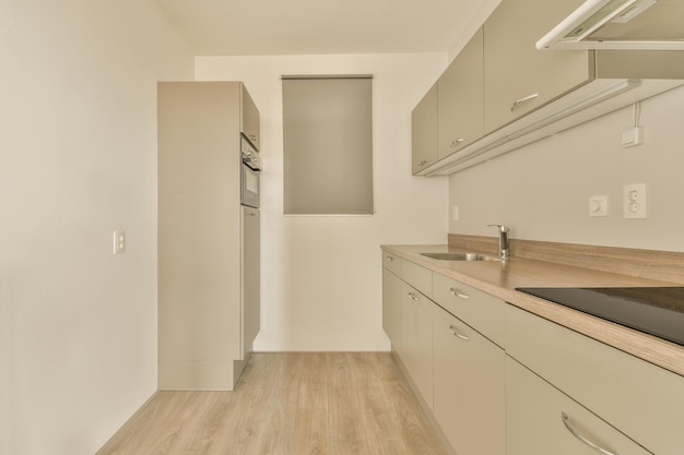 Una cucina con mobili bianchi e un frigorifero in acciaio inossidabile