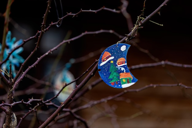 Una decorazione natalizia fatta a mano è appesa a un albero all'esterno.