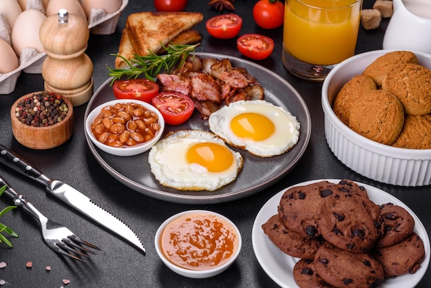 Una deliziosa colazione sana e nutriente con uova fritte pancetta fagioli un bicchiere di succo d'avena biscotti latte e marmellata Mangiare sano all'inizio della giornata