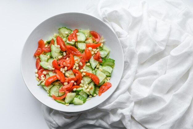 Una deliziosa insalata con fagioli, pomodori e cetrioli su sfondo bianco Fare una deliziosa colazione sana