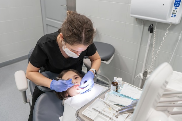 Una dentista pediatrica fornisce cure odontoiatriche di emergenza a un bambino