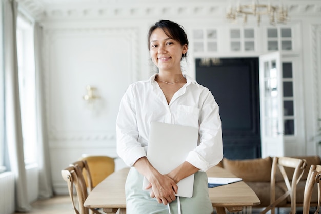 Una designer freelance femminile guarda nella telecamera e lavora come responsabile finanziario in ufficio