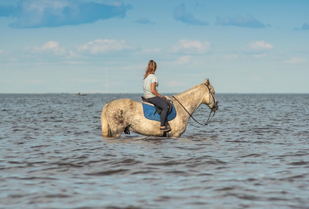 Una donna a cavallo nell'acqua