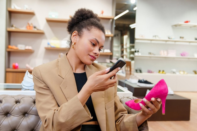 Una donna afroamericana fotografa un paio di scarpe selezionate