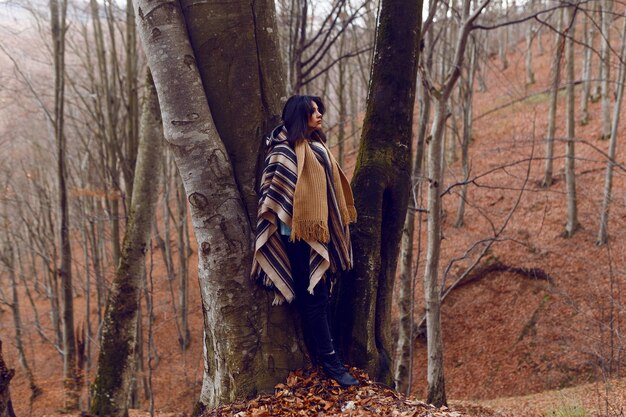 Una donna ammira i panorami autunnali in una fredda giornata nel bosco