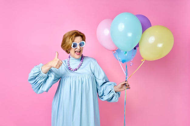 Una donna anziana adorabile e divertente con i palloncini