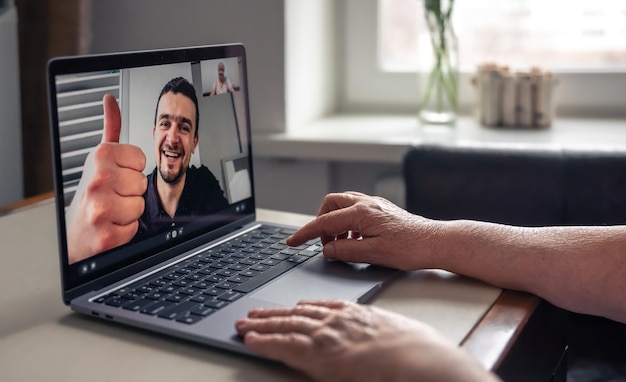 Una donna anziana comunica con suo figlio tramite collegamento video attraverso un laptop