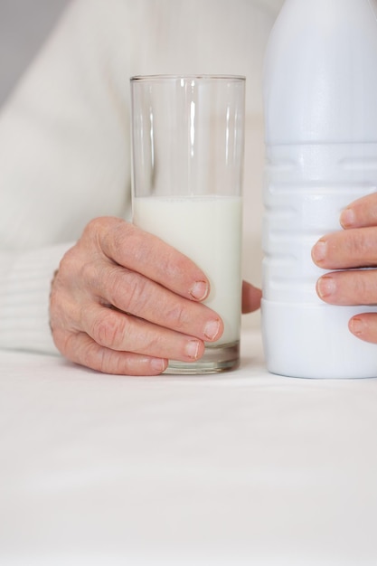 Una donna anziana di 80 anni tiene un bicchiere di latte