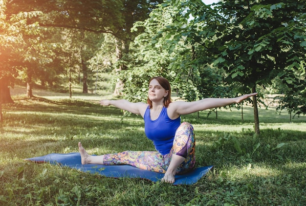 Una donna anziana fa yoga nel parco su un tappetino Esegue complessi esercizi di Asana conduce a una vita sana