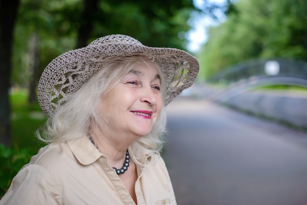 Una donna anziana nel parco sorridente