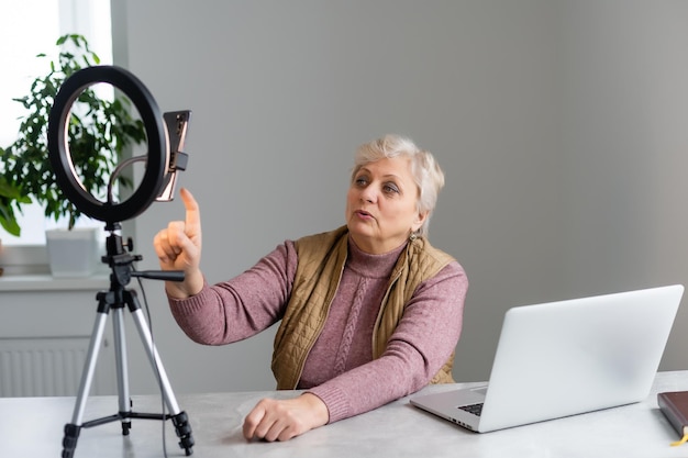 una donna anziana scrive un video per un blog.