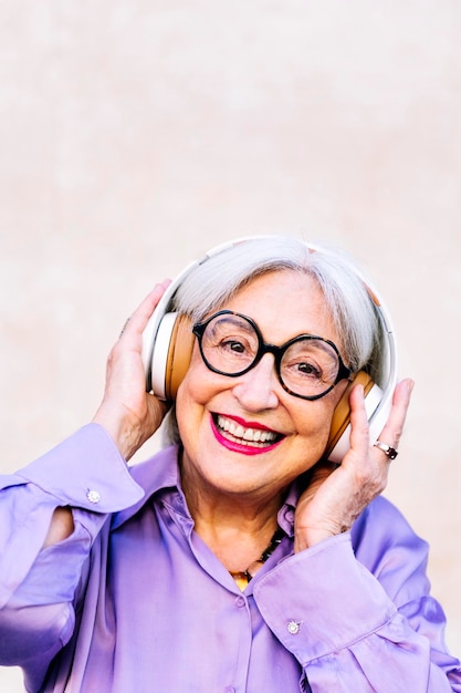 Una donna anziana sorridente che si diverte ad ascoltare musica