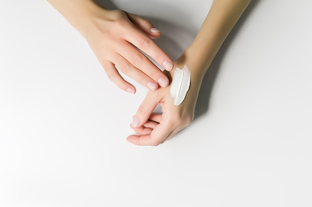 una donna applica una crema cosmetica alle mani concetto di cura della pelle delle mani