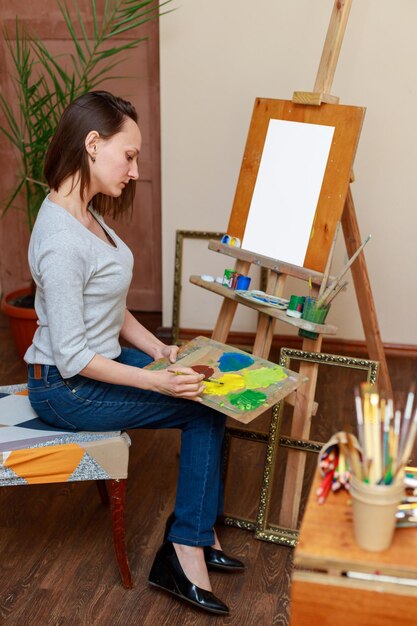 Una donna artista a un cavalletto in uno studio disegna