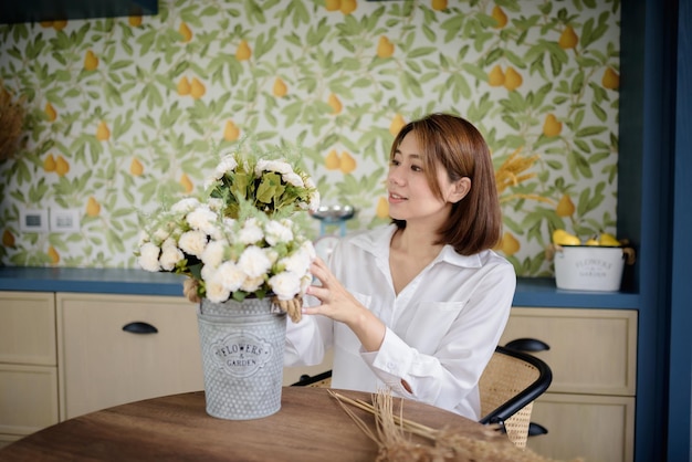 Una donna asiatica sta sistemando i fiori