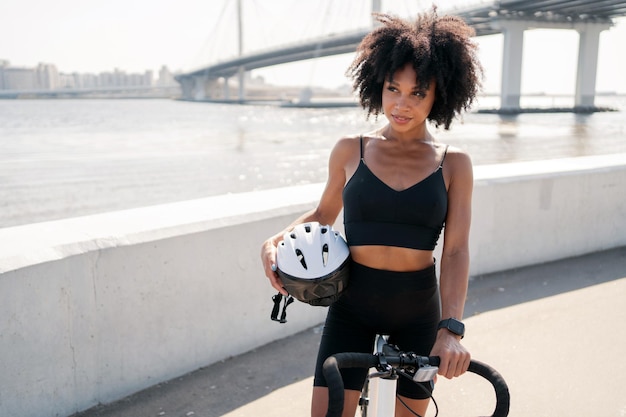 Una donna attiva è una giovane ciclista che va a fare una passeggiata all'aperto su una bicicletta bianca con un casco