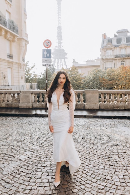 Una donna attraente in abito bianco cammina per le strade di Parigi