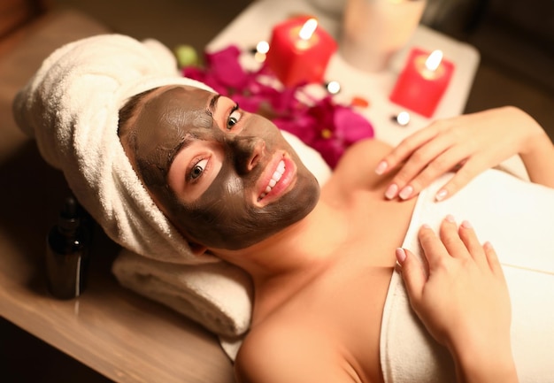 Una donna bellissima ha applicato una maschera al cioccolato nel salone della spa.