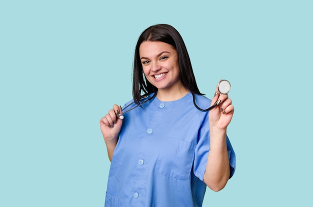 Una donna caucasica un'infermiera detiene uno stetoscopio su uno sfondo isolato Lei rappresenta la cura