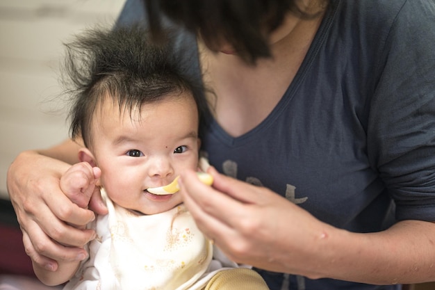 Una donna che allatta un bambino con una maglietta con su scritto "pappe".