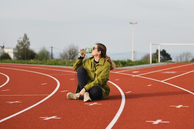 Una donna che beve acqua allo stadio