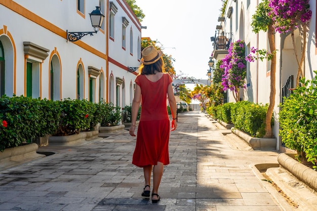 Una donna che cammina nel porto della fiorita città costiera di Mogan, nel sud di Gran Canaria, in Spagna