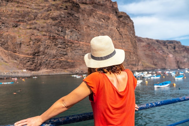 Una donna che guarda la spiaggia dal porto di pescatori del villaggio di Valle Gran Rey sulle isole Canarie di La Gomera