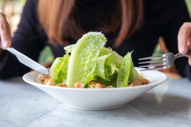 Una donna che mangia insalata caesar