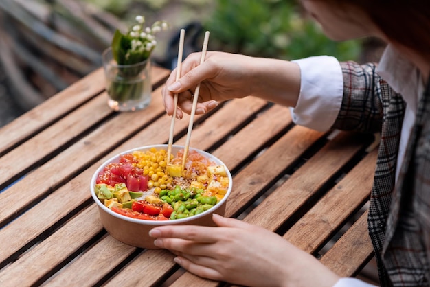 Una donna che mangia un poke in un parco