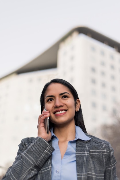 Una donna che parla al cellulare davanti a un edificio