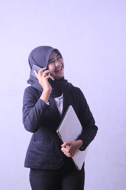 Una donna che parla al cellulare e indossa un hijab.