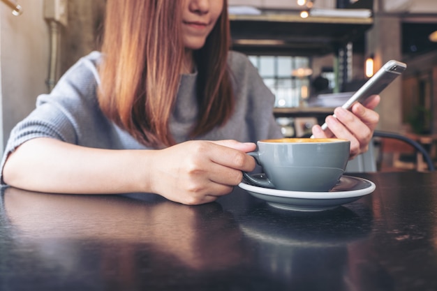 Una donna che tiene e utilizza uno smartphone