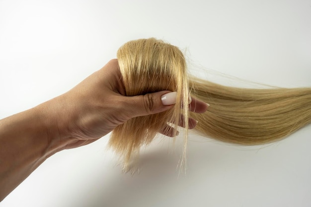 Una donna che tiene in mano una piega di capelli biondi
