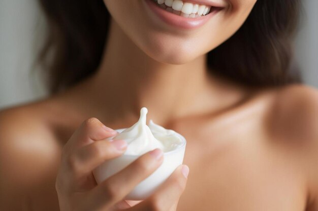 una donna che tiene una tazza di crema con un sorriso sul viso