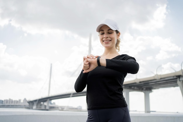 Una donna che utilizza un orologio fitness guarda il display durante un allenamento