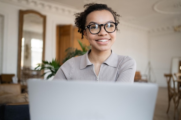 Una donna con gli occhiali è un manager che lavora in un ufficio utilizzando un laptop Il consulente