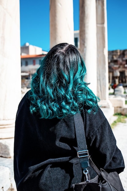 Una donna con i capelli blu attraversa un tempio ad Atene