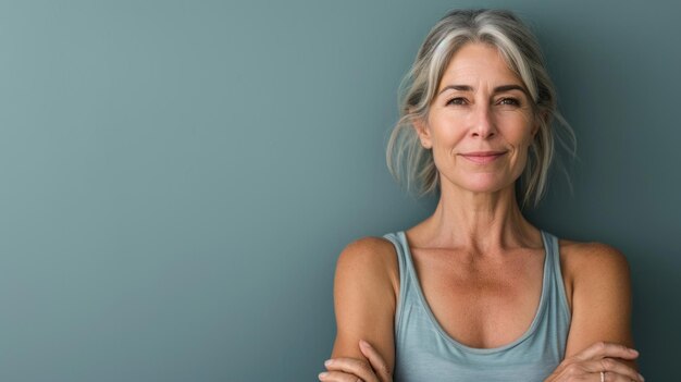 Una donna con i capelli grigi in piedi davanti a un muro blu