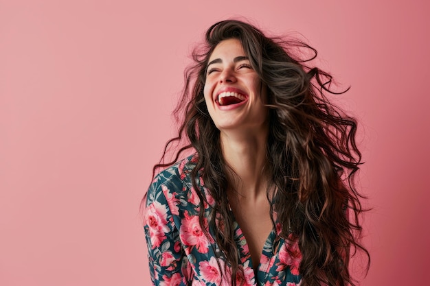 Una donna con i capelli lunghi che ride su uno sfondo rosa