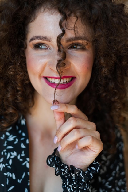 Una donna con i capelli ricci e un sorriso