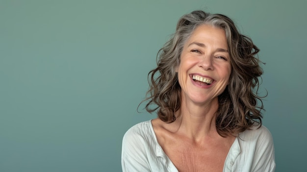 Una donna con i capelli ricci sorride e guarda la telecamera