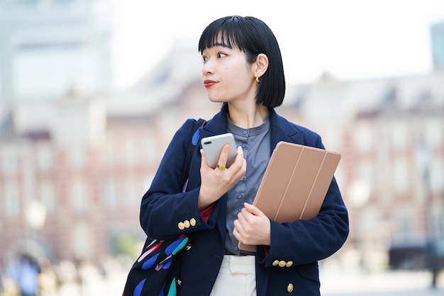 una donna con in mano uno smartphone