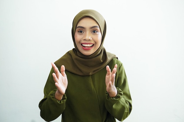 Una donna con l'hijab verde batte le mani.