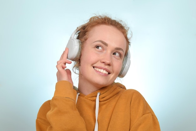 Una donna con le cuffie e un maglione giallo